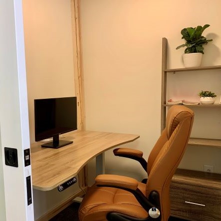 Private Office Image of an office with desk, monitor, brown chair and bookcase.